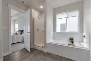 Bathroom featuring a bath, visible vents, a shower stall, and ensuite bath
