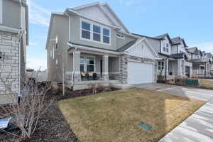 Craftsman inspired home with covered porch, board and batten siding, concrete driveway, and a garage