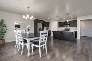 Dining space with recessed lighting, baseboards, a notable chandelier, and dark wood finished floors