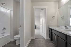 Bathroom with visible vents, baseboards, shower / washtub combination, toilet, and vanity