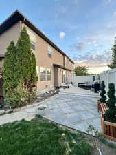 Rear view of house featuring a patio, fence, and stucco siding