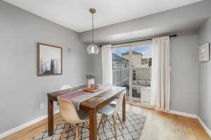 Dining area with light wood-type flooring and baseboards