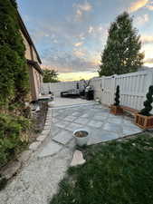 Patio terrace at dusk with a wooden deck and fence