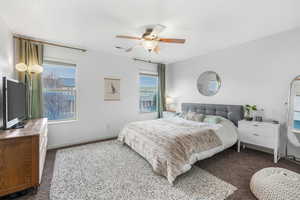 Bedroom featuring carpet, a ceiling fan, visible vents, and baseboards