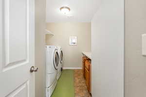 Laundry area featuring visible vents, stone finish floor, separate washer and dryer, baseboards, and laundry area