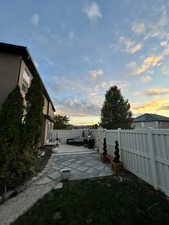 Yard at dusk featuring a deck and fence