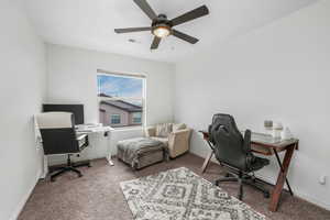 Home office with baseboards, visible vents, carpet floors, and ceiling fan