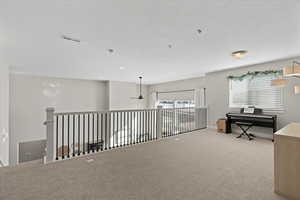Interior space with visible vents, carpet floors, recessed lighting, a textured ceiling, and a ceiling fan