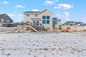 Snow covered property with stairway, a fenced backyard, a residential view, and stucco siding