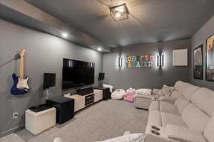 Living area featuring a textured ceiling and carpet