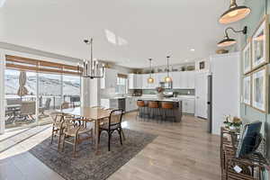 Dining space featuring a notable chandelier, recessed lighting, light wood-type flooring, and a textured ceiling