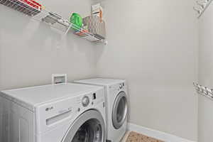 Laundry room with baseboards, laundry area, and washer and clothes dryer