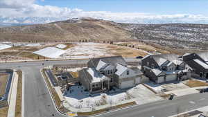 Snowy aerial view featuring a mountain view and a residential view