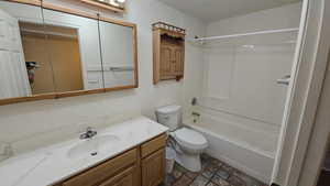 Bathroom with washtub / shower combination, toilet, and vanity