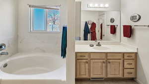 Full bath with visible vents, a garden tub, and vanity