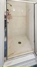 Bathroom featuring a marble finish shower