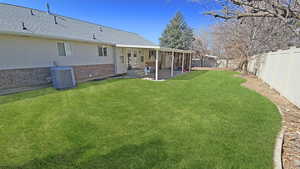 View of yard with a patio, central AC, entry steps, and a fenced backyard