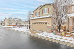 View of front of house with a residential view, concrete driveway, a garage, and stone siding