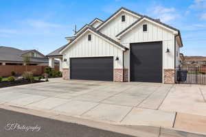Modern farmhouse featuring concrete driveway, an attached garage, fence, and board and batten siding