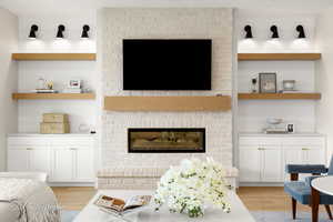 Living area with light wood-style flooring and a fireplace