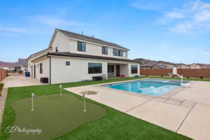 View of swimming pool featuring a pool with connected hot tub, central AC, a lawn, a fenced backyard, and a patio