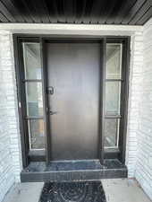 Doorway to property with brick siding