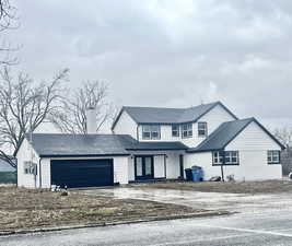 Traditional home featuring french doors, concrete driveway, and an attached garage