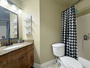 Full bathroom featuring baseboards, toilet, vanity, and tile patterned flooring