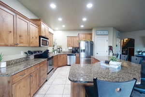 Kitchen featuring a spacious island, recessed lighting, appliances with stainless steel finishes, a kitchen breakfast bar, and a sink
