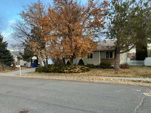 Obstructed view of property with brick siding and fence
