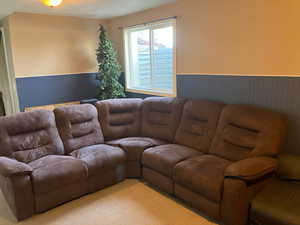 Living room with a wainscoted wall and light colored carpet