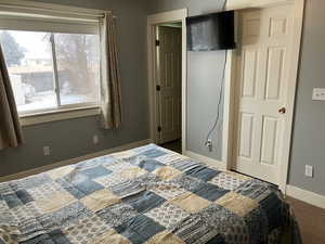 Carpeted bedroom featuring a closet and baseboards