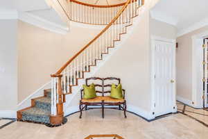 Stairway with baseboards and ornamental molding