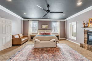 Bedroom with ornamental molding, a textured ceiling, a high end fireplace, carpet, and baseboards