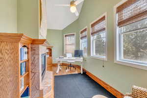 Office with a wealth of natural light, a tile fireplace, a ceiling fan, and wood finished floors