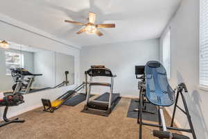 Workout room featuring baseboards, a healthy amount of sunlight, a textured ceiling, and a ceiling fan
