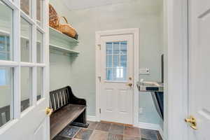 Mudroom with stone finish flooring and baseboards