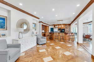Living room featuring recessed lighting, baseboards, and crown molding