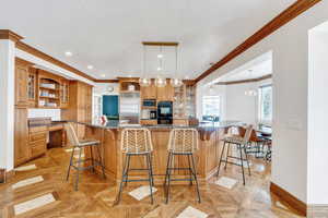 Kitchen featuring built in appliances, a breakfast bar, brown cabinets, built in study area, and open shelves