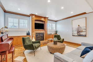 Living room with recessed lighting, a large fireplace, and ornamental molding