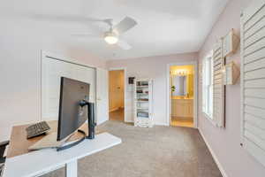 Office featuring baseboards, light colored carpet, a healthy amount of sunlight, and ceiling fan