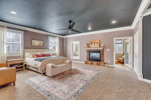 Carpeted bedroom with a tiled fireplace, recessed lighting, baseboards, and ornamental molding