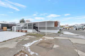 View of front of home featuring an attached carport, a storage shed, and an outdoor structure