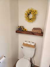 Half bathroom with toilet and built in shelving