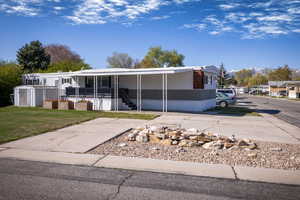 Manufactured / mobile home featuring a porch and a front lawn