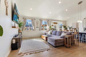 Living area featuring light wood-type flooring, baseboards, and a healthy amount of sunlight