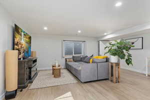 Living area featuring recessed lighting, baseboards, and light wood-style flooring