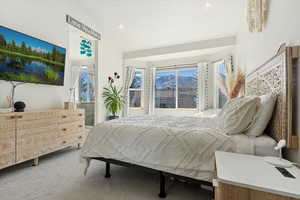 Carpeted bedroom with recessed lighting and vaulted ceiling