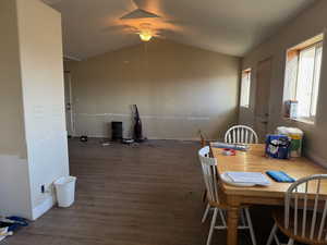 Dining area featuring wood finished floors, a ceiling fan, and vaulted ceiling