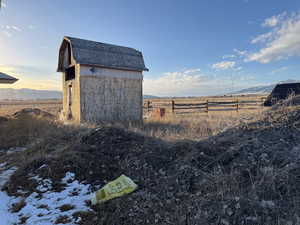 View of outdoor structure with a rural view, an outdoor structure, and fence